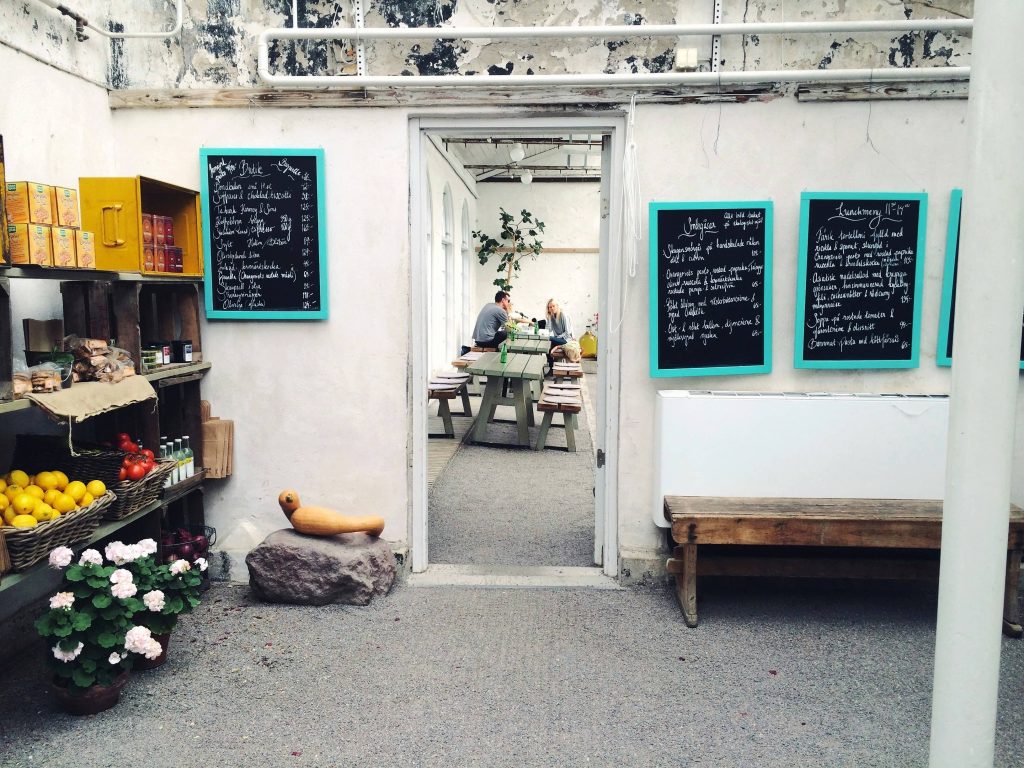Doorway with picnic tables in the distance, a group of people sitting and talking at one table inside