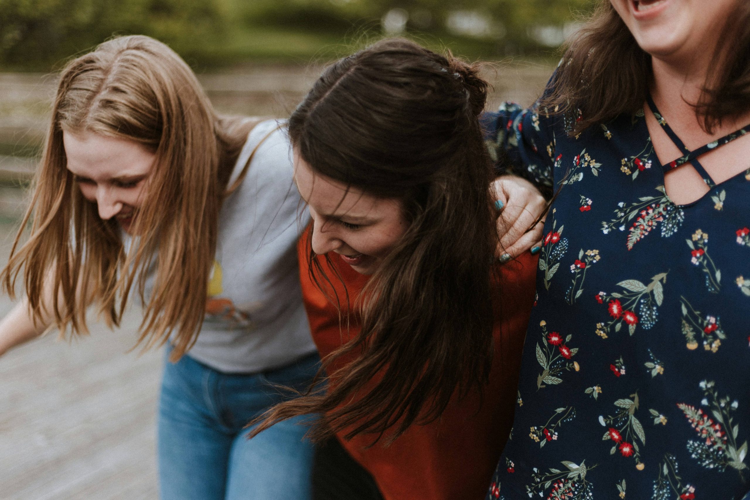 Women girls friend group laughing arms around each other