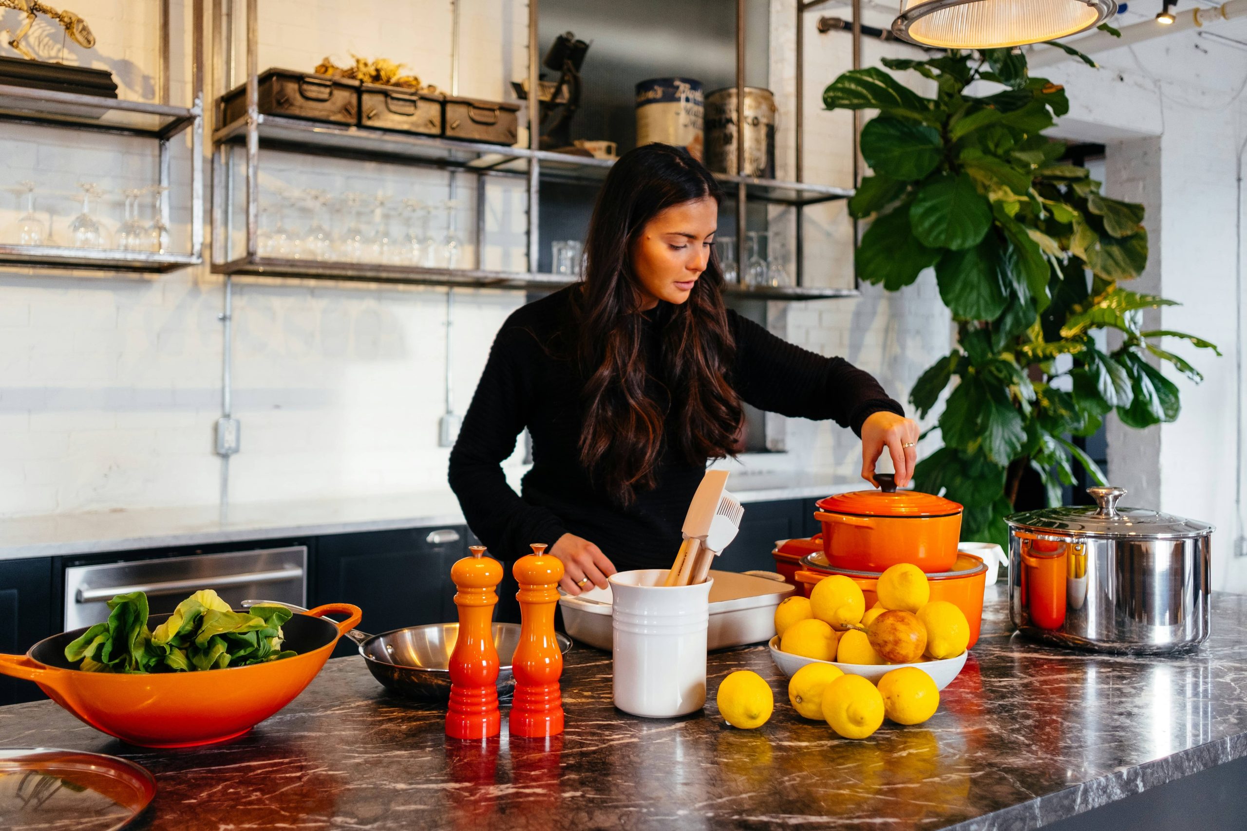 Woman in kitchen grabbing pots