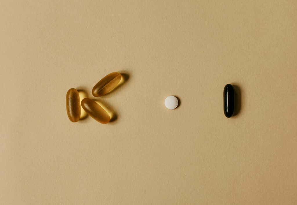 Pills supplements against pale yellow surface